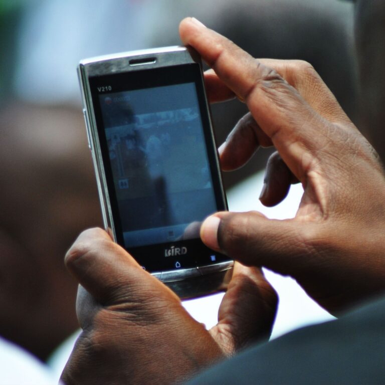 Person's hands holding cell phone.